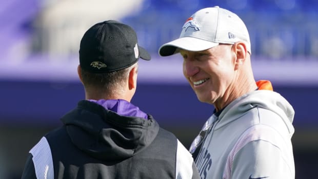 Baltimore Ravens head coach John Harbaugh (left) talks with Denver Broncos coach Jerry Rosburg (right) prior to the game at M&T Bank Stadium.